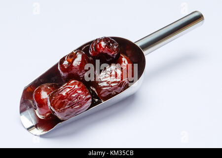 Scoop full of date fruits isolated on white background. Clipping path Stock Photo