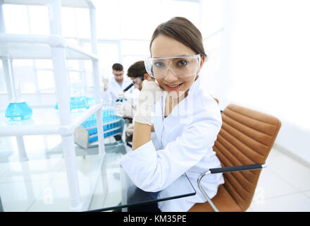 Investigator checking test tubes, Woman wears protective goggles Stock Photo