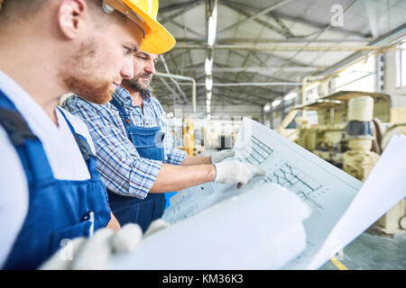 Construction Workers Inspecting Electric Scheme Stock Photo