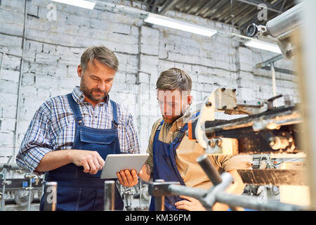 Two Factory Workers operating Modern Equipment Stock Photo
