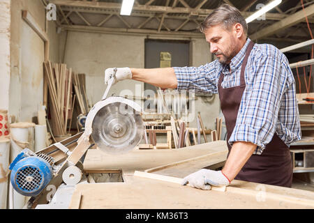 Carpenter Cutting Wood Stock Photo