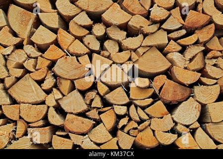 Background of chopped and stacked firewood for wood fuel. Stock Photo