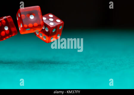 Picture of several red dice falling on green table,, empty space for text Stock Photo