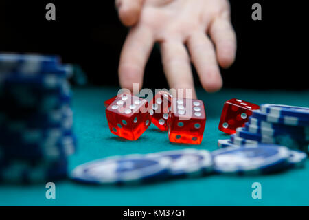 Picture of man throwing dice on table with chips in casino Stock Photo