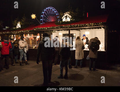 People browsing, shopping and enjoying Edinburgh's Christmas, in Princes Street gardens. Big Wheel in background. Scotland, UK Stock Photo