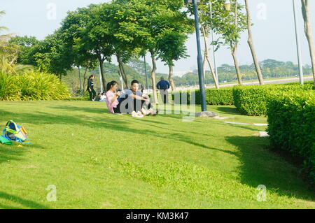 People are relaxing on the lawn of the Shenzhen Bay Park. In Shenzhen, China. Stock Photo