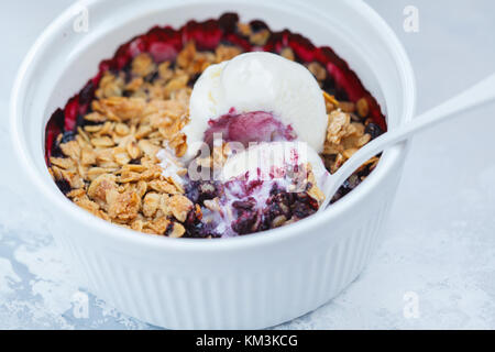 Berry crumble with cream ice-cream in a ceramic form. Stock Photo