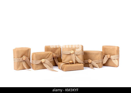Gift box for Christmas wrapped in brown recycled paper with ribbon bow and button isolated on white Stock Photo