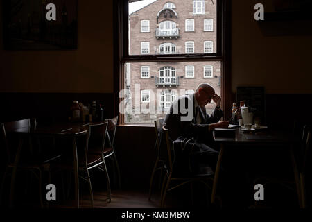 Business man sitting at a cafe working backlit Stock Photo