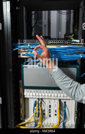 Close-up Of Engineers hand checking Server In Data Center Stock Photo