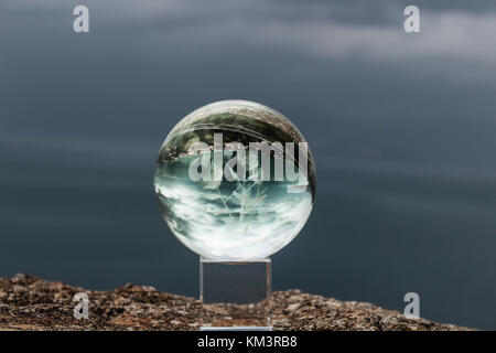crystal ball on a rock with sea and sky on the background before the storm on a winter day greece Stock Photo