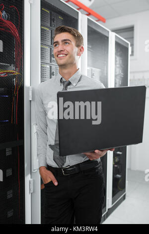 Young business man with laptop working in data center Stock Photo