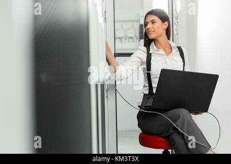 Portrait of technician working on laptop in server room Stock Photo