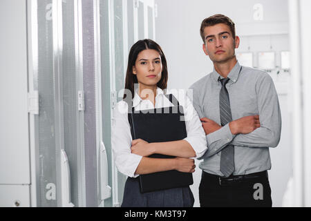Team of technicians working together on servers at the data centre Stock Photo