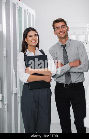 Team of technicians working together on servers at the data centre Stock Photo
