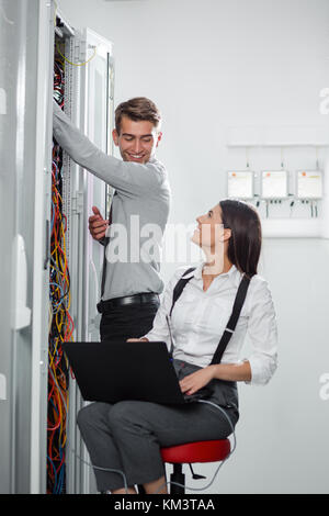 Team of technicians working together on servers at the data centre Stock Photo