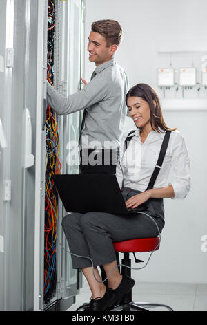 Team of technicians working together on servers at the data centre Stock Photo
