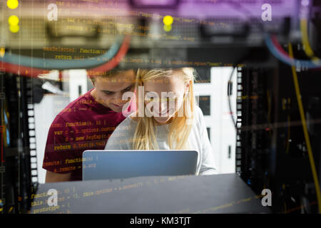 Team of technicians working together on servers at the data centre Stock Photo