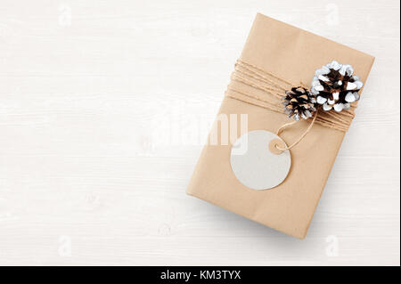 Mockup Christmas gift box wrapped in brown recycled paper and tied and tag sack rope with, top view Stock Photo