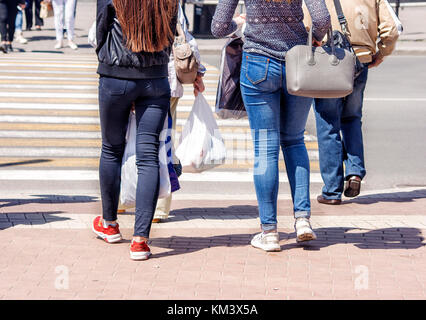 pedestrians crossing a street in the city on sunny summer day Stock Photo