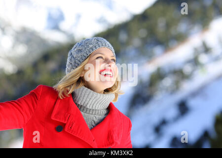 Portrait of a candid woman dreaming on a snowy mountain in winter Stock Photo