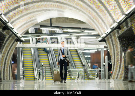 Businessman in front of escalators on a metro station. Stock Photo