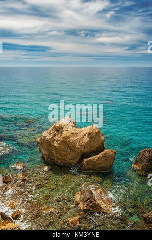 A view of a huge boulder near to one of the beaches by cliffs at Makrygialos on the Greek island of Crete. Stock Photo