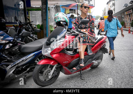 Woman sat on a scooter motorcycle waiting. Stock Photo