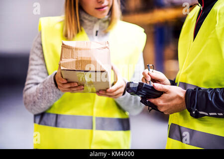 Young warehouse workers working together. Stock Photo