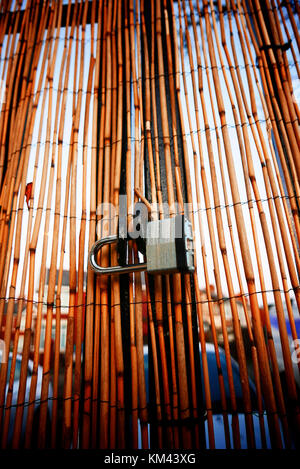 Steel padlock on thin bamboo curtain Stock Photo