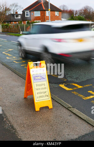 Yellow plastic A board warning drivers to not park within the zig zag lines in front of schools,Lancashire,UK Stock Photo