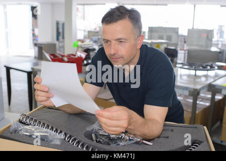man reading instruction for 3d printer on tablet computer Stock Photo