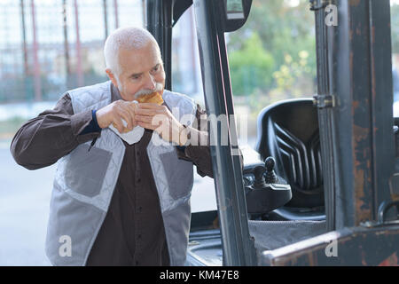 Fork lift driver eating a sandwich Stock Photo