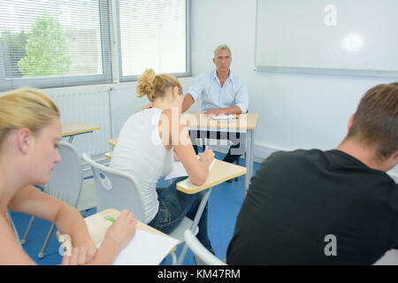 students passing exam in class Stock Photo