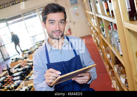 salesman taking inventory in wine store Stock Photo