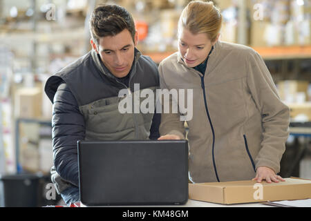 warehouse managers using laptop in warehouse Stock Photo