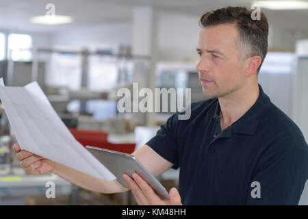 attractive businessman is using a digital tablet in his office Stock Photo
