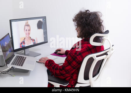 young graphic designer in bathrobe working at home office using computer Stock Photo