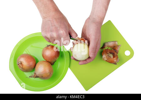 Cook in the kitchen with a knife cleans the onions from the husks Stock Photo