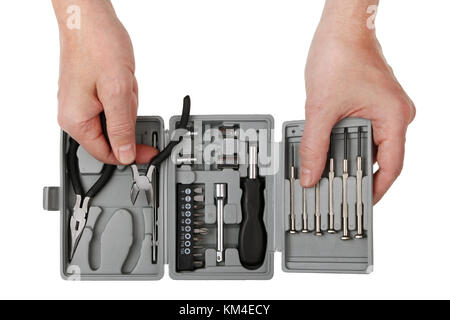 The technician elderly repairman takes from the tool set steel side cutters. Isolated on white top view studio shot Stock Photo