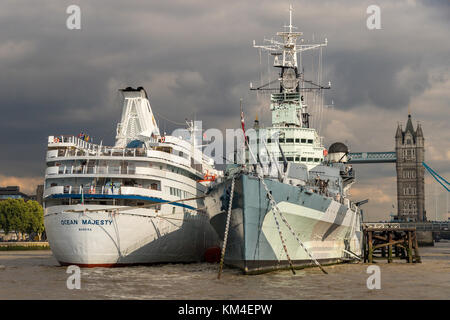 HMS Belfast with The cruise ship MV Ocean Majesty moored along side in The Pool Of London , with Tower Bridge In the Background Stock Photo