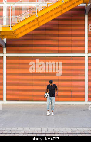 Young man playing with a soccer ball in urban area Stock Photo