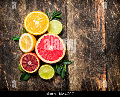 Citrus background. Fresh citrus fruits - Lemons, oranges, limes, grapefruits. On wooden background. Stock Photo