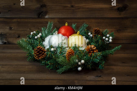 Decorated Advent wreath with shiny Christmas balls and snow on a wooden background. Stock Photo