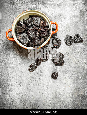 Prunes in a bowl. On rustic background . Stock Photo