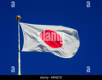 National Flag of Japan with the Red Sun waving in the wind Stock Photo