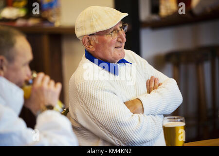 Two men at a lawn bowls club seated with pints of beer. Post match analysis. Stock Photo