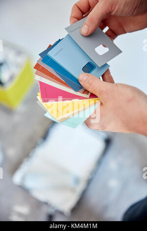 A person holding a paint colour chart, choosing a colour from the colour wheel. Stock Photo