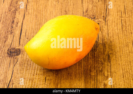 Sweet mango fruit over the wooden background Stock Photo