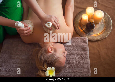 Woman getting thai herbal compress massage in spa. Close up Stock Photo